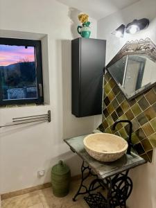 a bathroom with a stone sink and a window at Maison de charme avec piscine in Simiane-la-Rotonde