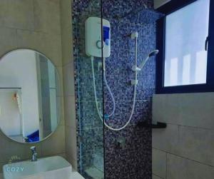 a bathroom with a shower with a sink and a mirror at The Shore Seaview A1817 in Kota Kinabalu