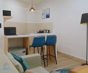 a living room with a table and two blue chairs at The Shore Seaview A1817 in Kota Kinabalu +23 photos