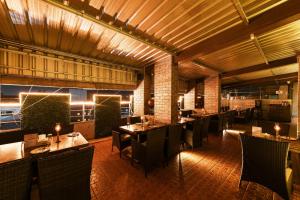 a restaurant with tables and chairs in a room at Hotel Roopa in Mysore