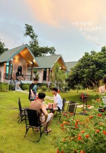 a group of people sitting in chairs in a yard at OLALA Villa & Homestay Bungalow in Hanoi +13 photos