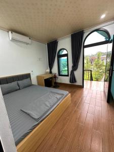 a bedroom with a bed and a wooden floor at OLALA Villa & Homestay Bungalow in Hanoi