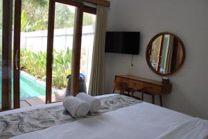 a bedroom with a bed and a mirror and a television at Layana One in Klungkung +109 photos