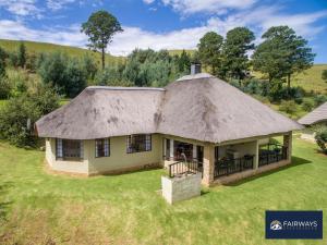 an image of a house with a thatched roof at Fairways Drakensberg Resort in Drakensberg Garden