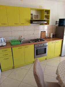 a kitchen with yellow cabinets and a sink at Apartment More 1 in Savar