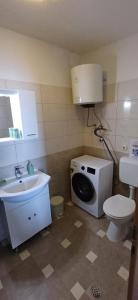 a bathroom with a toilet sink and a washing machine at Apartment More 1 in Savar