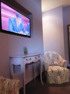 TV a/nebo společenská místnost v ubytování Logis Hôtel Le Glacier