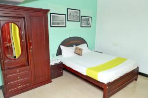 um quarto com uma cama com uma cómoda e um espelho em Elk Hill Palace em Ooty
