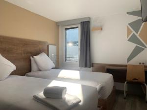 Postel nebo postele na pokoji v ubytování Val Hôtel Montbéliard Sud