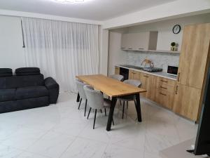 a kitchen and dining room with a wooden table and chairs at Parc Residence 3 in Sighetu Marmaţiei +11 photos