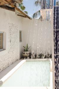 a swimming pool in front of a white wall at Zanzibari holiday home by Liv Zanzibar in Paje