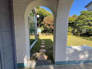 an archway leading into a yard with a lawn sidx sidx at Pension J in Paju
