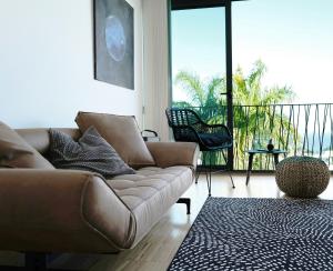 a living room with a couch and a balcony at FEEL GOOD Ferienapartment mit Meerblick und Pool in Santa Úrsula
