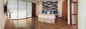 a bedroom with a bed with blue pillows on it at Binnacle Negombo in Negombo