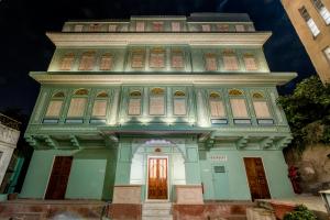 斋浦尔Raghunath Haveli - A Boutique Homestay的前面有红色门的高楼