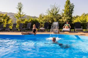 two women and a child playing in a swimming pool at Lázeňský a Wellness hotel NIVAMARE in Luhačovice