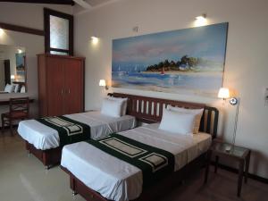 a hotel room with two beds and a painting on the wall at Anugaa in The City in Colombo