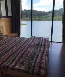 una camera con letto e vista sul lago di NaNa Farm a Bak Kan