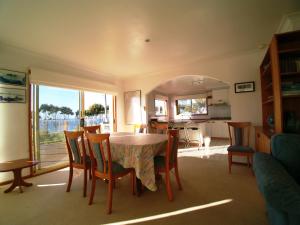 
a dining room table and chairs in a house at 3 Bay Lane in Kianga
