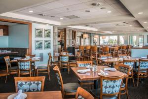 マスキーゴンにあるShoreline Inn & Conference Center, an Ascend Collection Hotelの木製のテーブルと椅子のあるダイニングルーム