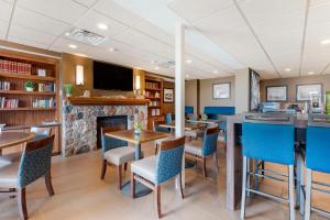 a restaurant with tables and chairs and a fireplace at Lift Bridge Lodge, an Ascend Collection Hotel in Duluth
