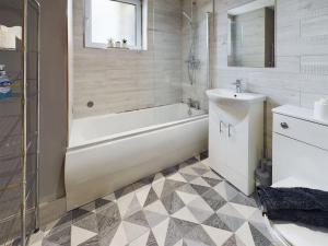 a white bathroom with a tub and a sink at Stunning 2BR Apt in City Centre in Belfast