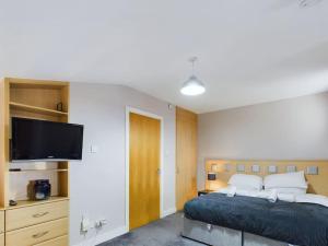 a bedroom with a bed and a flat screen tv at Stunning 2BR Apt in City Centre in Belfast