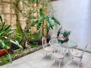 a patio with a table and chairs and plants at XL Massive Art-Filled Home in Central Area, WALK to Sliema, St Julian's in Il-Gżira