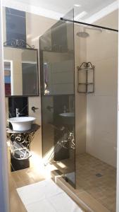 Un baño con ducha de cristal y lavabo. en Thandi's Guest House, en East London