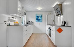 a kitchen with white cabinets and an orange arrow on the wall at Holiday Home Jerup With Fireplace I in Jerup