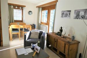 a living room with a chair and a table at Chalet Valeria in Saas-Fee