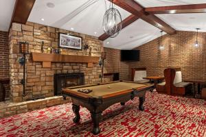a pool table in a room with a brick fireplace at Wingate by Wyndham South Bend - Notre Dame in South Bend