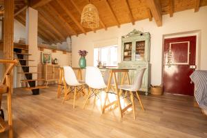 a dining room with a table and white chairs at Tribo da Praia in São Luis