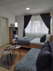 a living room with two beds and a couch at Happiness Apartment Skopje in Skopje