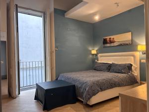 a bedroom with a bed and a large window at Base Napoli Mergellina in Naples