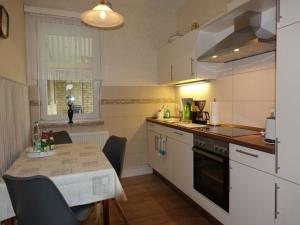 a small kitchen with a table and a table and chairs at Ferienwohnung Strauß in Neuberend