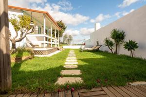 a garden with a stone path in front of a house at Tribo da Praia in São Luis