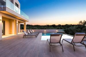a deck with chairs and a swimming pool on a house at Estel Residences in Chania Town