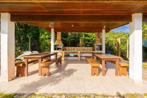 a pavilion with benches and tables on a patio at Lindo Loft na Praia de Barra do Una à beira do Rio in São Sebastião