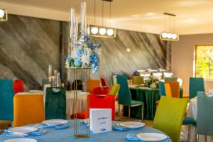 een eetkamer met een tafel en kleurrijke stoelen bij La Casa Blanca in Vladimirescu