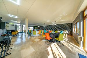 een eetkamer met kleurrijke stoelen en tafels bij La Casa Blanca in Vladimirescu