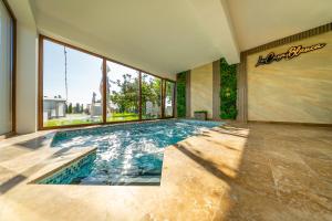 een zwembad in een kamer met een groot raam bij La Casa Blanca in Vladimirescu