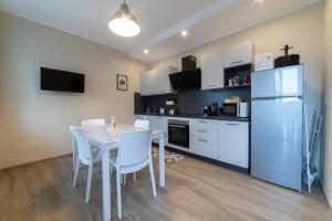 a kitchen with a table and a refrigerator at Casa Rubbo - Appartamento 'Como' nelle Langhe in Alba +7 photos