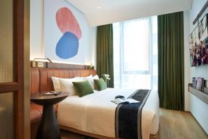 a hotel room with a bed and a table at Citadines Connect City Centre Singapore in Singapore