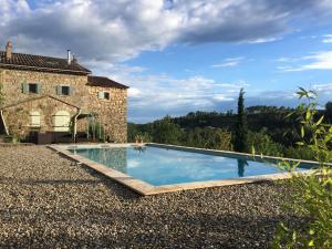 een zwembad voor een stenen huis bij Mas de la Giralde - Bed and Breakfast in Payzac