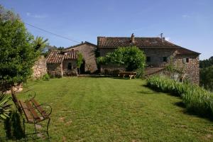 een tuin met een bankje voor een huis bij Mas de la Giralde - Bed and Breakfast in Payzac