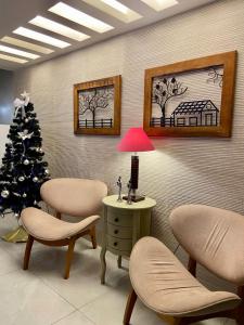 a waiting room with a christmas tree and chairs and a lamp at Pousada Capua Buzios in Búzios