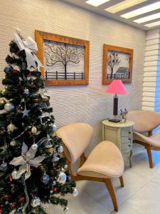 a christmas tree in a room with two chairs at Pousada Capua Buzios in Búzios