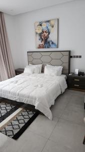 Villa IROKO في أبيدجان: غرفة نوم بسرير كبير مع ملاءات بيضاء