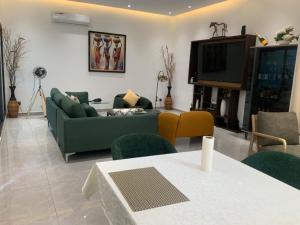 Villa IROKO في أبيدجان: غرفة معيشة بها أريكة وجهاز تلفزيون